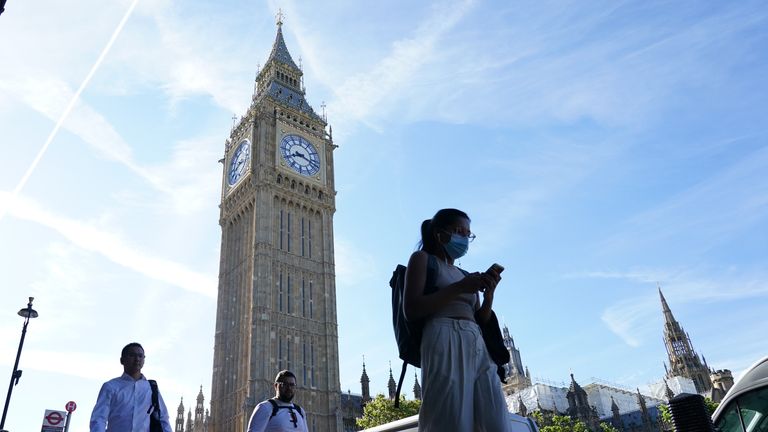 People walk past Big Ben at the Houses of Parliament in London. Picture date: Friday July 15, 2022.
