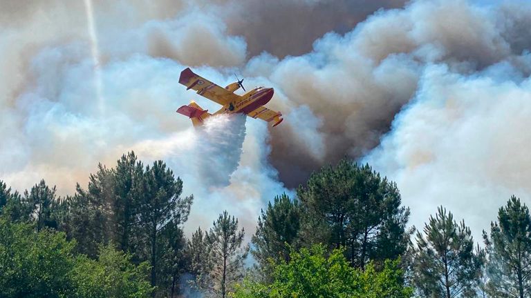 This photo provided by the fire brigade of the Gironde region (SDIS 33) shows a Canadair plane fighting wildfire near La Teste-de-Buch, southwestern France, Saturday, July 16, 2022. Strong winds and hot, dry weather are frustrating French firefighters&#39; efforts to contain a huge wildfire that raced across pine forests in the Bordeaux region Saturday for a fifth straight day, one of several scorching Europe in recent days. (SDIS 33 via AP)