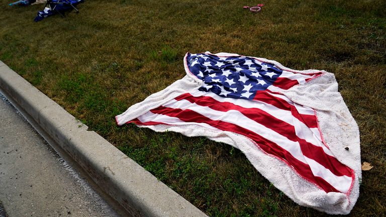 Empty chairs and an American flag blanket lie on the ground after a mass shooting at the Highland Park Fourth of July parade in downtown Highland Park, a Chicago suburb on Monday, July 4, 2022. (AP Photo/Nam Y. Huh)