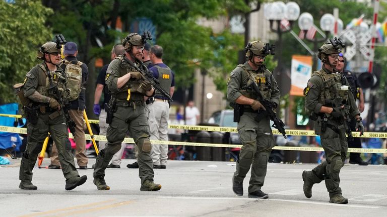 Law enforcement search after a mass shooting at the Highland Park Fourth of July parade in downtown Highland Park, Ill., a suburb of Chicago, on Monday, July 4, 2022. (AP Photo/Nam Y. Huh)