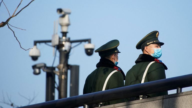 Paramilitary police members wearing protective face masks stand near surveillance cameras at the Bund, following new cases of the coronavirus disease (COVID-19), in Shanghai, China January 20, 2022. REUTERS/Aly Song
