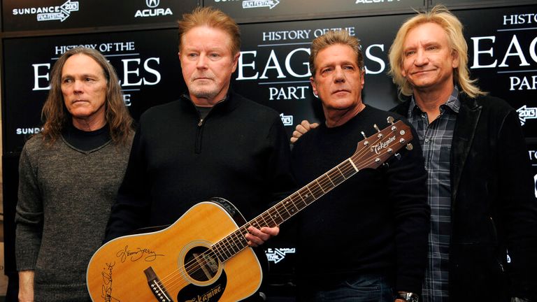 FILE - Members of The Eagles, from left, Timothy B. Schmit, Don Henley, Glenn Frey and Joe Walsh pose with an autographed guitar after a news conference at the Sundance Film Festival, in Park City, Utah, Jan. 19, 2013. Three people were charged Tuesday, July 12, 2022, in an alleged conspiracy involving the handwritten lyrics to the classic rock juggernaut "Hotel California." (Photo by Chris Pizzello/Invision/AP, File)