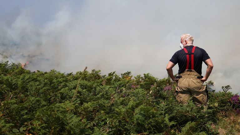 A firefighter attends a gorse bush fire, during a heatwave near Zennor, Cornwall, Britain, July 19, 2022. REUTERS/Tom Nicholson
