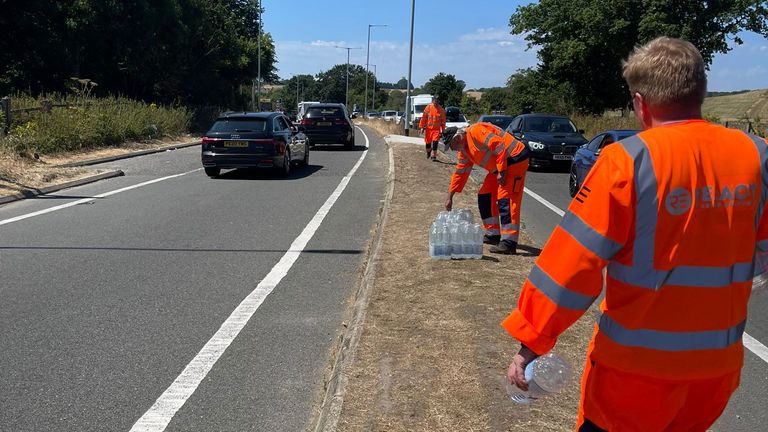 Staff hand out water bottles to people in cars near Folkestone