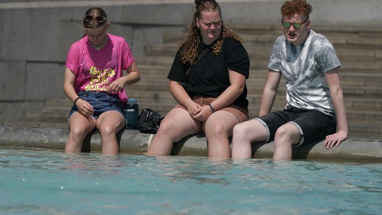 People with their feet in a fountain at Trafalgar Square in central London. Picture date: Tuesday July 19, 2022.
