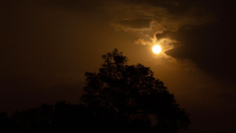 Superlua - Portugal 13 de julho de 2022, Portugal, Tomar: A lua cheia brilha entre as nuvens, que se dissiparam por um breve momento enquanto o ar se enche de fumaça dos incêndios florestais no centro do país.  Milhares de bombeiros continuam a combater vários incêndios em todo o país em Portugal.  Foto: Viola Lopes/picture-alliance/dpa/AP Images