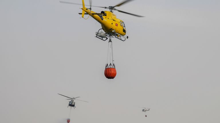 Un hélicoptère transporte de l'eau pendant des travaux d'extinction d'incendies de forêt près de Becerril de la Sierra, dans la périphérie de Madrid, le mardi 12 juillet 2022. Une vague de chaleur, la deuxième pour l'Espagne en moins d'un mois et la première cette année pour le Portugal, devrait durer au moins jusqu'au week-end, ont annoncé mardi des responsables.  Les températures déjà élevées grimpent régulièrement, faisant craindre de déclencher d'autres incendies de forêt incontrôlables.  (AP Photo/Bernat Armangue)