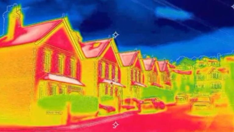 A thermal image showing a street, with houses and the road radiating heat