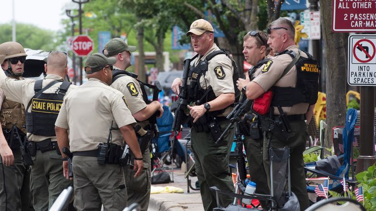 Illinois Eyalet Polisi'nden memurlar, 4 Temmuz 2022 Pazartesi günü 4 Temmuz geçit töreninde Highland Park, Illinois'de meydana gelen birden fazla kurbanın dahil olduğu bir çekimin gerçekleştiği yerin yakınında konuşuyorlar. (Joe Lewnard/Daily Herald via AP) PIC:Ap