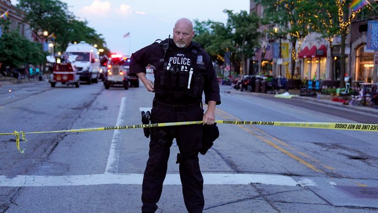 A police officer holds up police tape at the scene of a mass shooting at the Highland Park Fourth of July parade in downtown Highland Park, a Chicago suburb, on Monday, July 4, 2022 
PIC:AP