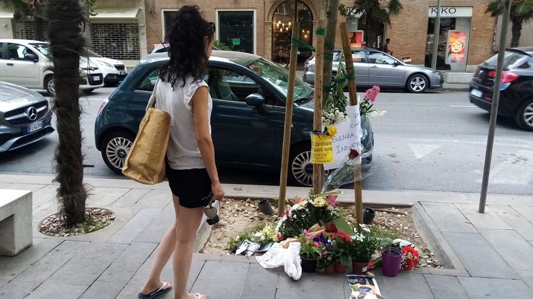 A woman looks flowers where the Nigerian street vendor Alika Ogorchukwu has been murdered, in Civitanova Marche, Italy, Saturday, July 30, 2022. (AP Photo/Chiara Gabrielli)