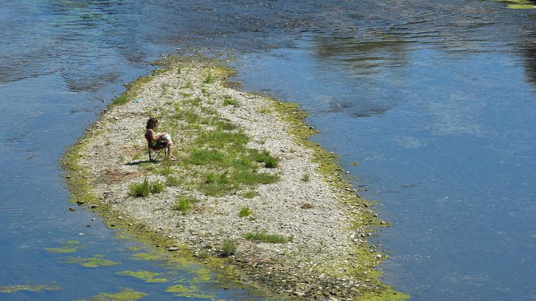 Norte da Itália atingido pela seca sofre uma segunda onda de calor no verão Uma pessoa senta-se no leito seco de um rio Pó perto de Carmagnola enquanto partes do rio mais longo da Itália secaram devido à pior seca em 70 anos Turim, Itália 15 de julho de 2022 REUTERS /Massimo Pinca