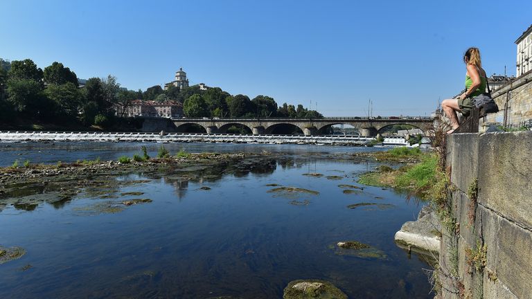 Kuraklığa yakalanan kuzey İtalya ikinci yaz sıcak hava dalgasını çekiyor İtalya'nın en uzun nehri son 70 yılın en kötü kuraklığı nedeniyle kuruduğu için Po'nun kuru nehir yatağının yanında bir kadın oturuyor, Torino, İtalya 15 Temmuz 2022. REUTERS/Massimo Pinca