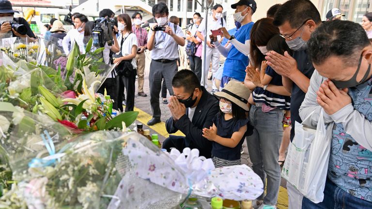 İnsanlar eski Başbakan Shinzo Abe'nin vurulduğu yerin yakınındaki derme çatma bir anıtta dua ediyor.  Resim: AP