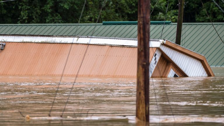 Homes are flooded by Lost Creek, Ky., Thursday, July 28, 2022. Heavy rains caused flash flooding and landslides as storms batter parts of central Appalachia.  Kentucky Gov. Andy Beshear said it was one of the worst floods in state history.  (Ryan C. Hermens/Lexington Herald-Leader via AP)