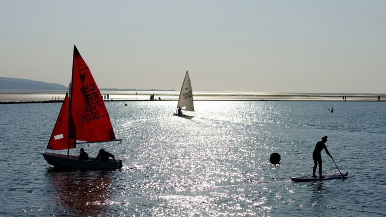 People sail and paddle board on the marine lake in West Kirby, Britain, April 24, 2021. REUTERS/Phil Noble