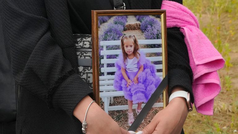 A woman carries a portrait of Liza, 4-year-old girl killed by Russian attack, during a funeral ceremony in Vinnytsia, Ukraine, Sunday, July 17, 2022. Wearing a blue denim jacket with flowers, Liza was among 23 people killed, including two boys aged 7 and 8, in Thursday&#39;s missile strike in Vinnytsia. Her mother, Iryna Dmytrieva, was among the scores injured. (AP Photo/Efrem Lukatsky)