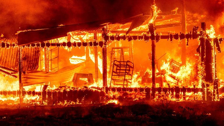 A structure burns as the Oak Fire crosses Darrah Rd. in Mariposa County, Calif., on Friday, July 22, 2022. (AP Photo/Noah Berger)