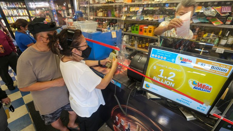 İnsanlar, Hawthorne, California'daki Blue Bird Liquor mağazasından Mega Millions piyango bileti satın alıyor.  Resim: AP