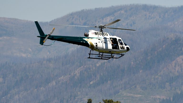 A helicopter from Montana Fish, Wildlife and Parks flies around the Ovando, Mont., area on Tuesday, July 5, 2021, in search of a bear that killed a camper early that morning. The search for the bear continued Wednesday.  (Tom Bauer/Missoulian via AP)