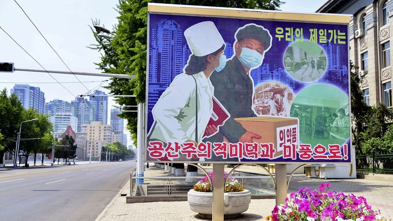 Pyongyang'da koronavirüs hastalığının (COVID-19) yayılmasıyla ilgili artan korkular arasında tıbbi ürün taşımacılığı sahnesini gösteren bir işaret.  Mayıs 2022. Resim: Kyodo