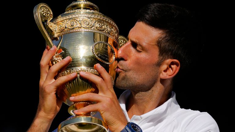 10 Temmuz 2022 Pazar günü Londra'da düzenlenen Wimbledon tenis şampiyonasının on dördüncü gününde tek erkekler finalinde Avustralyalı Nick Kyrgios'u mağlup eden Sırp Novak Djokovic kupayı kutluyor. AP Fotoğrafı/Kirsty Wigglesworth)