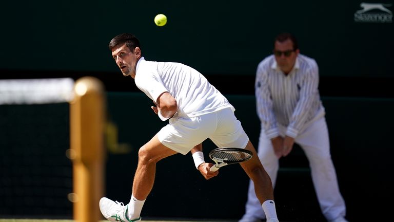 Novak Djokovic hits through the legs as he battles Cameron Norrie during the men's singles semi-final on day 12 of the 2022 Wimbledon Championships at the All England Lawn Tennis and Croquet Club, Wimbledon.  Photo date: Friday, July 8, 2022.