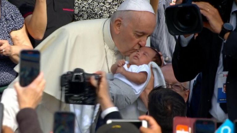 Pope Francis is driven around a stadium in Edmonton, Canada kissing babies. On his visit he apologised for the Catholic Church&#39;s role in Canadian indigenous school abuse.