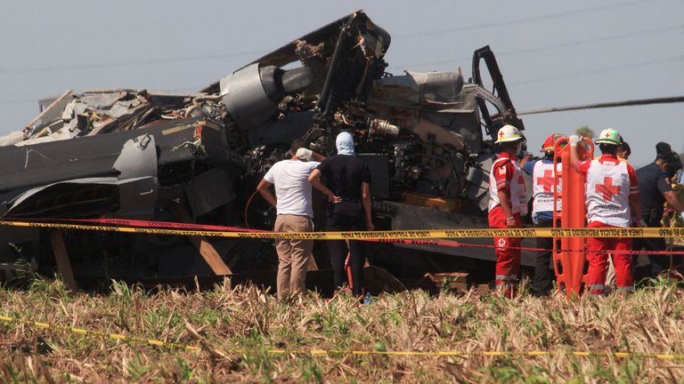 Red Cross paramedics stand next to the wreckage of a Black Hawk military helicopter that crashed in Los Mochis, Sinaloa state, Mexico