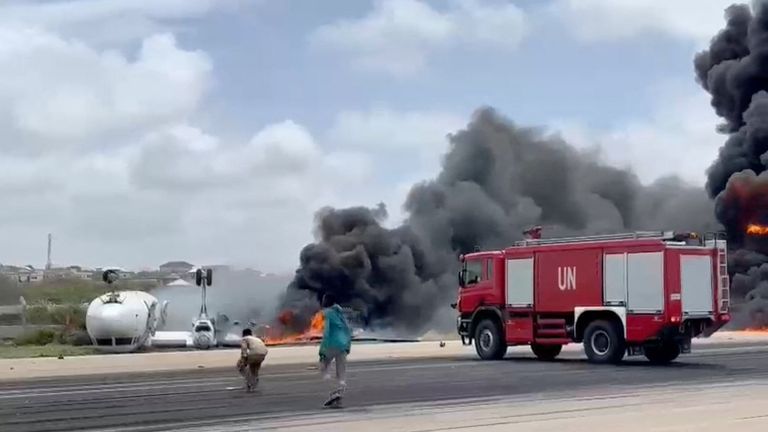 Smoke billows from a plane that flipped over after a crash landing, in Mogadishu, Somalia, July 18, 2022, in this screen grab obtained from a social media video obtained by Reuters. THIS IMAGE HAS BEEN SUPPLIED BY A THIRD PARTY NO RESALES. NO ARCHIVES
