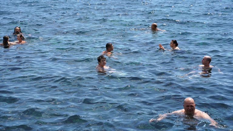 İnsanlar, Katanya'da, yazın ikinci sıcak hava dalgasında denizde yıkanıyor İnsanlar, yazın ikinci sıcak hava dalgasında, Katanya, İtalya'da, 14 Temmuz 2022'de denizde banyo yapıyor. REUTERS/Antonio Parrinello