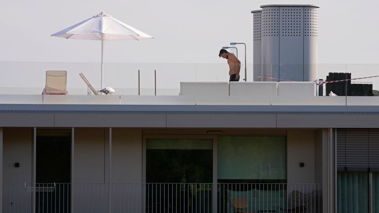 Ein Mann in Badehose badet auf dem Dach eines Wohnhauses in Madrid, Spanien, Dienstag, 12. Juli 2022. Eine neue Hitzewelle in Spanien und Portugal wird voraussichtlich bis Ende der Woche andauern.  Die bereits steigenden Temperaturen steigen stetig und erhöhen die Angst vor weiteren unkontrollierbaren Waldbränden.  (AP Foto/Paul White)