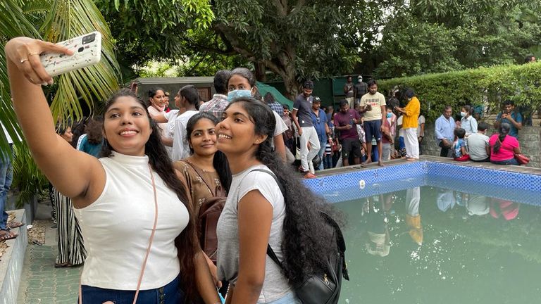 Frauen machen Selfies am Pool der Präsidentenresidenz