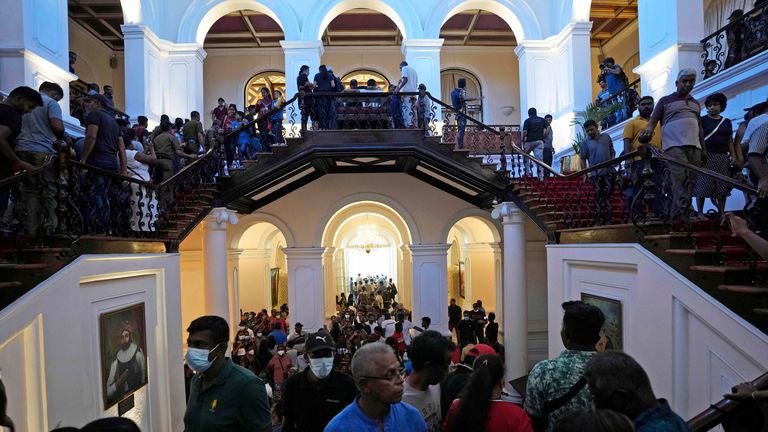 Protesters look around at the president's official residence. Pic: AP