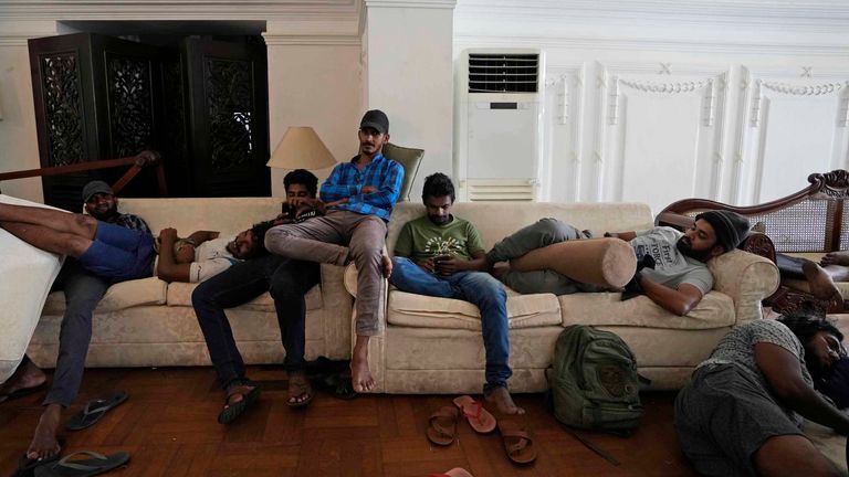 Protesters rest on sofas in the living hall of prime minister's official residence. Pic: AP