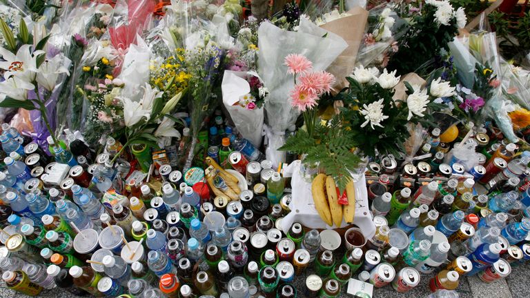 Flowers and beverages are offered to victims killed on Sunday in Tokyo&#39;s Akihabara district in Tokyo June 11, 2008. Japanese police arrested 25-year-old Tomohiro Kato at the scene for driving a truck into a crowd of Sunday shoppers in Akihabara, Tokyo&#39;s biggest electronics shopping district, and then walking down the street stabbing people at random. REUTERS/Yuriko Nakao (JAPAN)