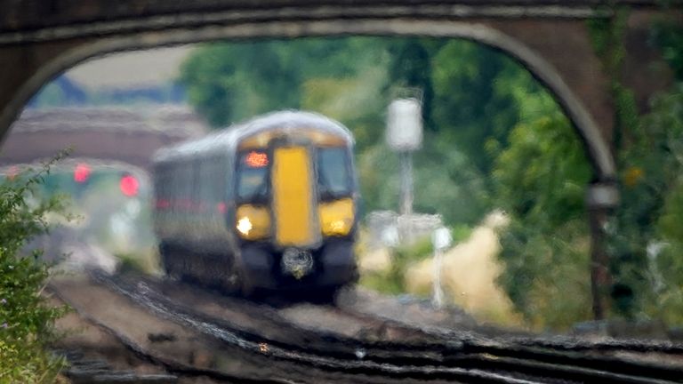 A train passes through heat haze on a railway line near Ashford in Kent