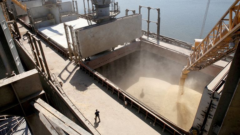 FILE PHOTO: A shipyard worker watches as barley grain is mechanically poured into a 40,000-ton ship at the shipping dock of a Ukrainian agricultural exporter in the city of Nikolaev, southern Ukraine 