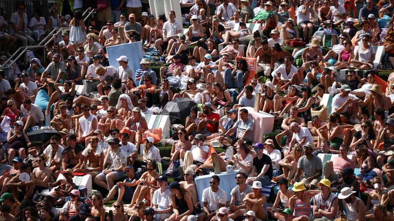 People watch the Wimbledon men’s singles final tennis match on a giant screen next to the Regent’s canal at Granary Square, during hot weather in London, Britain, July 10, 2022. REUTERS/Henry Nicholls
