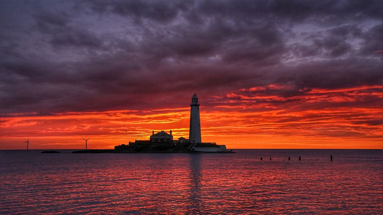 A fire coloured sky above St Mary&#39;s Lighthouse in Whitley bay on the North East coast of England just before sunrise. Picture date: Friday July 15, 2022.

