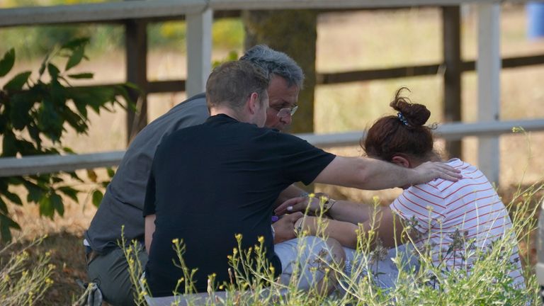 A woman is comforted close to the blaze in the village of Wennington, east London, where 100 firefighters are tackling a fire. London Fire Brigade has declared a major incident due to "a huge surge" in blazes across the capital amid the 40C heat. Picture date: Tuesday July 19, 2022.
