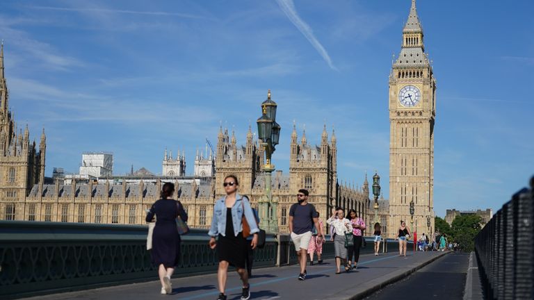 People walk across Westminster Bridge in London. Picture date: Friday July 15, 2022.
