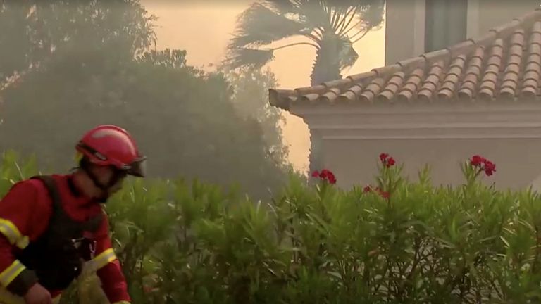 Videodan alınan bu hareketsiz görüntüde, 13 Temmuz 2022'de Portekiz'deki Quinta do Lago'da orman yangını alevlenirken bir itfaiyeci çalışıyor.  REUTERS aracılığıyla REUTERS TV/Luis Ferreira