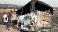 Men inspect a bus that was burnt following a wildfire in El Kala, in Al Taref province, Algeria August 18, 2022. REUTERS/Ramzi Boudina
