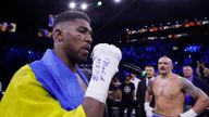 Joshua on the microphone after the end of the fight, as Usyk waits in the background