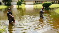 Hinds County Emergency Management Operations deputy director Tracy Funches, right, and operations coordinator Luke Chennault, wade through flood waters in northeast Jackson, Miss., Monday, Aug. 29, 2022, as they check water levels. Flooding affected a number neighborhoods that are near the Pearl River. (AP Photo/Rogelio V. Solis)