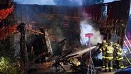 Firefighters work on hot spots in the front section of the home which collapsed during an early morning fatal fire on First Street in Nescopeck, Pa., Friday, Aug. 5, 2022. The fire was reported around 2:30 a.m. The cause of the fire remains under investigation. (Jimmy May/Bloomsburg Press Enterprise via AP)