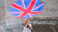 A young boy battles with an umbrella on the south bank in London. Yellow weather warnings are in place for most of the UK on Tuesday after weeks of little rain and warm conditions have caused droughts, leaving land parched. Picture date: Tuesday August 16, 2022.

