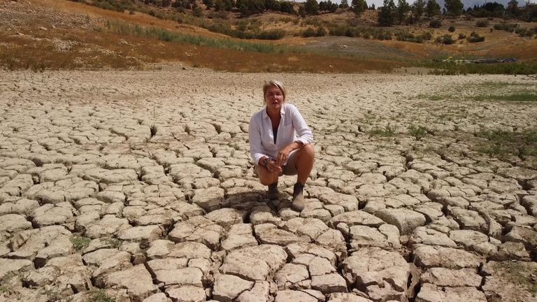 Sky&#39;s Alex Crawford stands on dry earth that was once fully submerged in Malaga, Spain