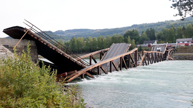 Cars are seen over the collapsed bridge over the River Laagen in Gudbrandsdalen, Norway, August 15, 2022. Geir Olsen/NTB via REUTERS ATTENTION EDITORS - THIS IMAGE WAS PROVIDED BY A THIRD PARTY. NORWAY OUT. NO COMMERCIAL OR EDITORIAL SALES IN NORWAY.
